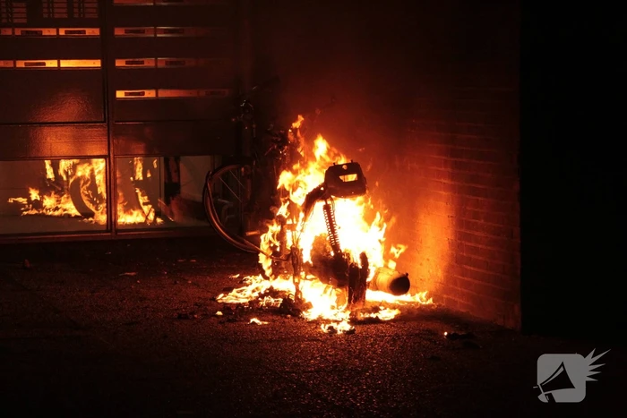 Brandweer blust brandende scooter tegen appartementencomplex
