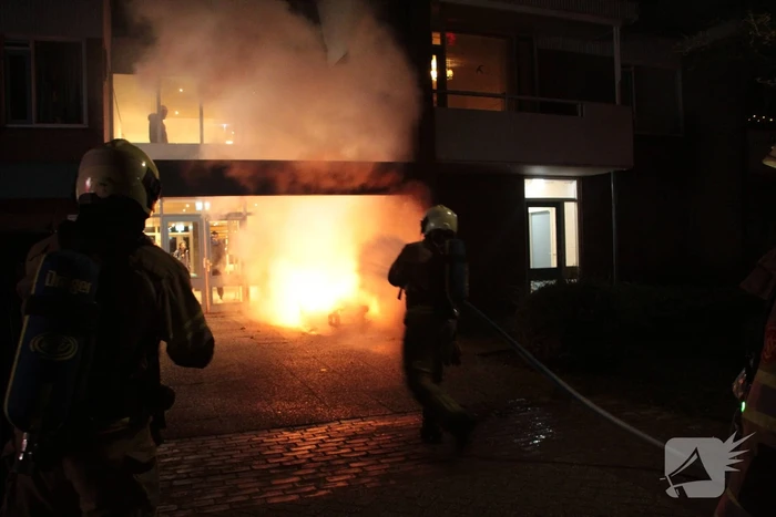 Brandweer blust brandende scooter tegen appartementencomplex