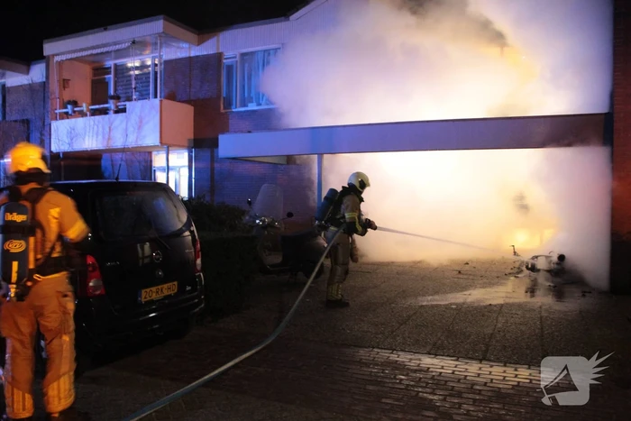 Brandweer blust brandende scooter tegen appartementencomplex