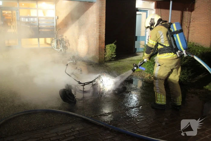 Brandweer blust brandende scooter tegen appartementencomplex