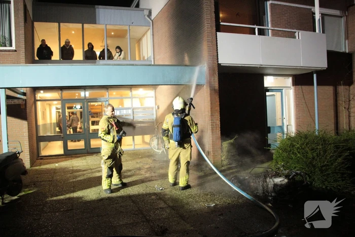 Brandweer blust brandende scooter tegen appartementencomplex