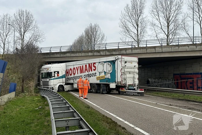 Vrachtwagen schaart en botst tegen viaduct