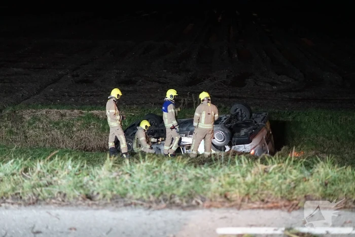 Auto raakt van weg, schampt boom en belandt ondersteboven in de sloot