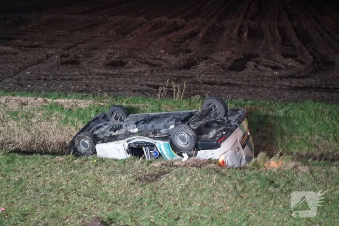 Auto raakt van weg, schampt boom en belandt ondersteboven in de sloot