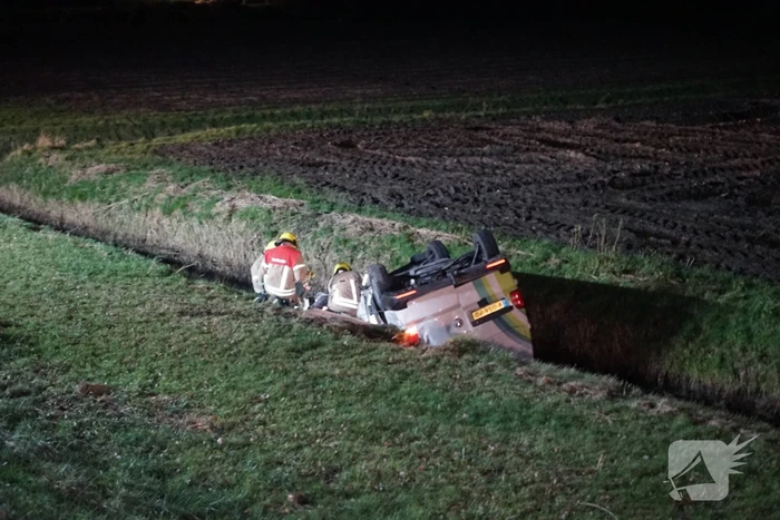 Auto raakt van weg, schampt boom en belandt ondersteboven in de sloot