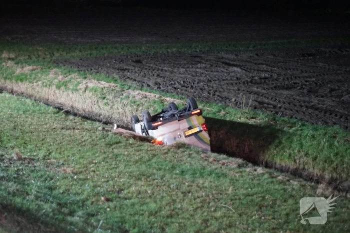 Auto raakt van weg, schampt boom en belandt ondersteboven in de sloot