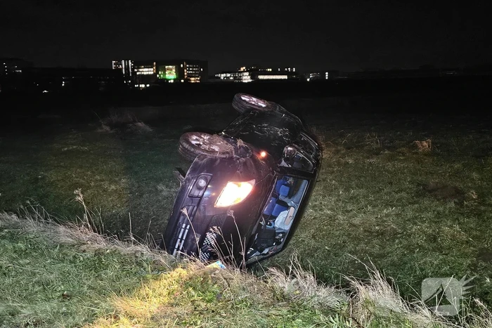Auto belandt op zijkant in sloot na botsing met vrachtwagen