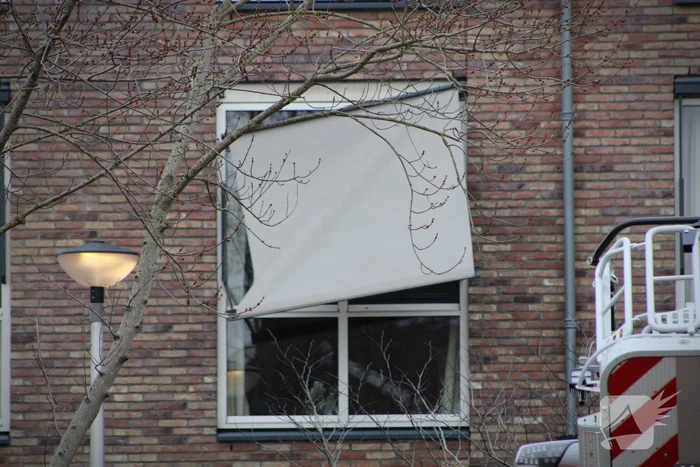 Brandweer zet loshangende zonnescherm vast