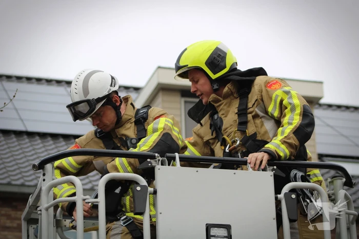 Brandweer zet loshangende zonnescherm vast