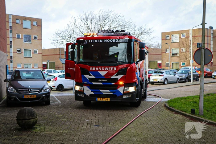 Containers onder flatgebouw in brand