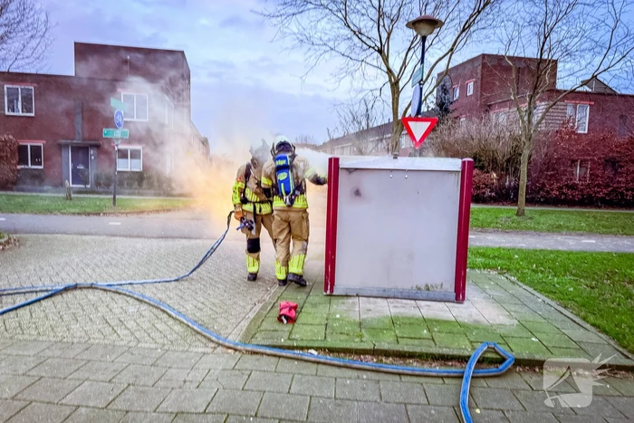Brandweer blust brandende papiercontainer