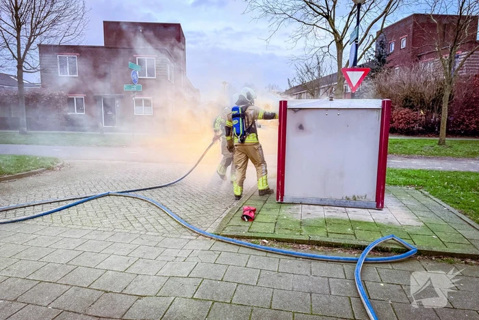 Brandweer blust brandende papiercontainer