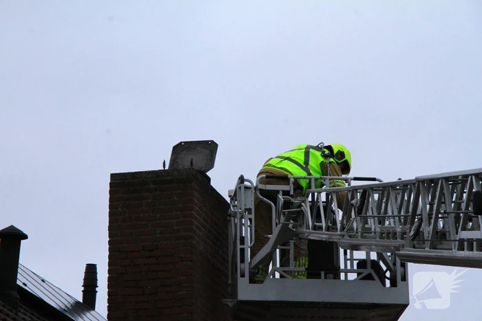 Brandweer blust brand in schoorsteen