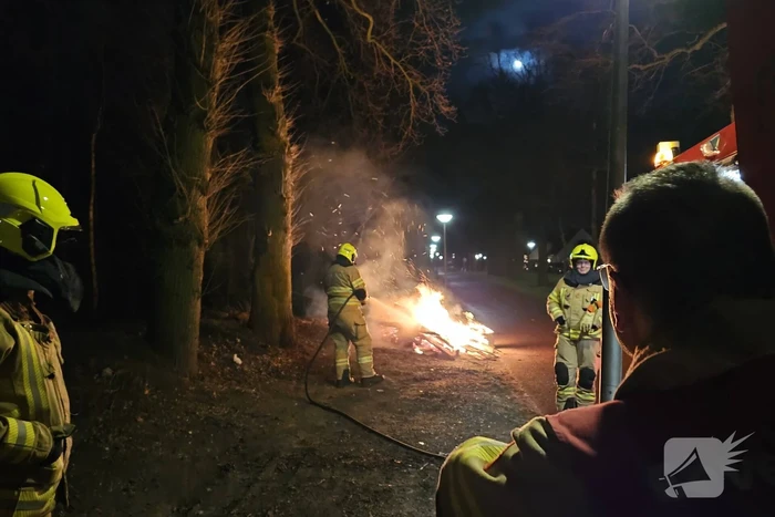 Brandweer blust stapel brandend hout