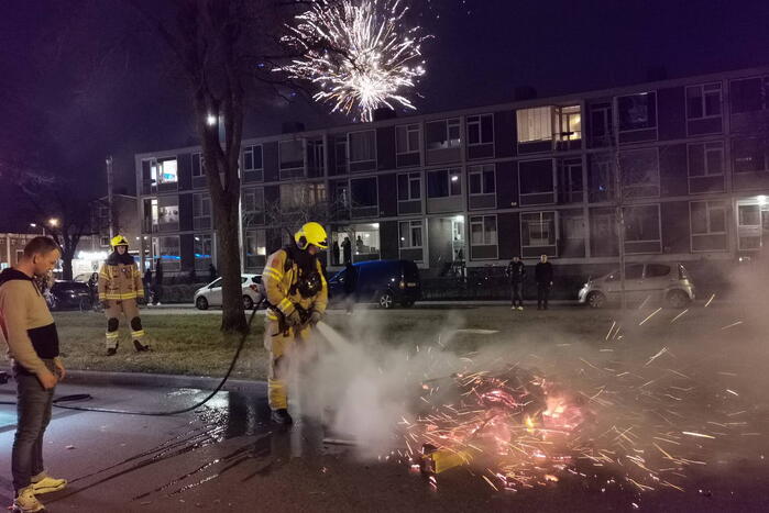 Brandweer blust berg afval op straat