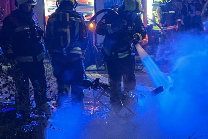 Brandweer blust brandende vuurton en scooter