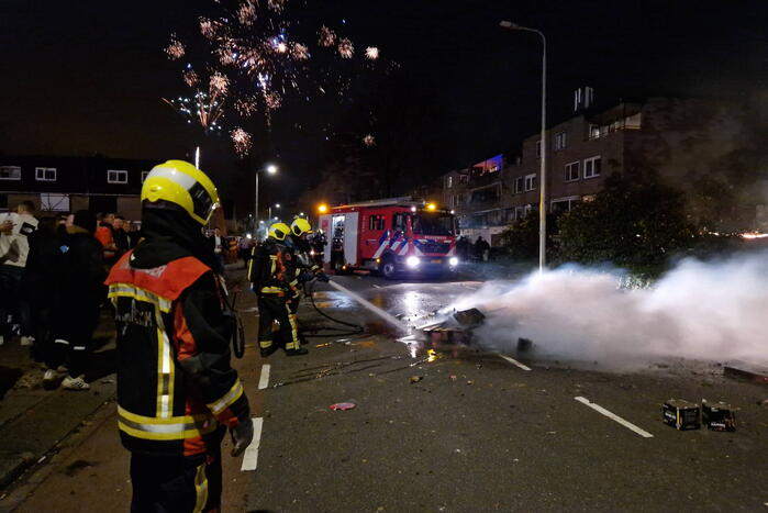 Brandweer blust brandend vuurwerkafval