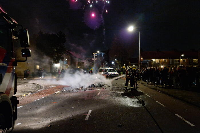 Brandweer blust brandend vuurwerkafval