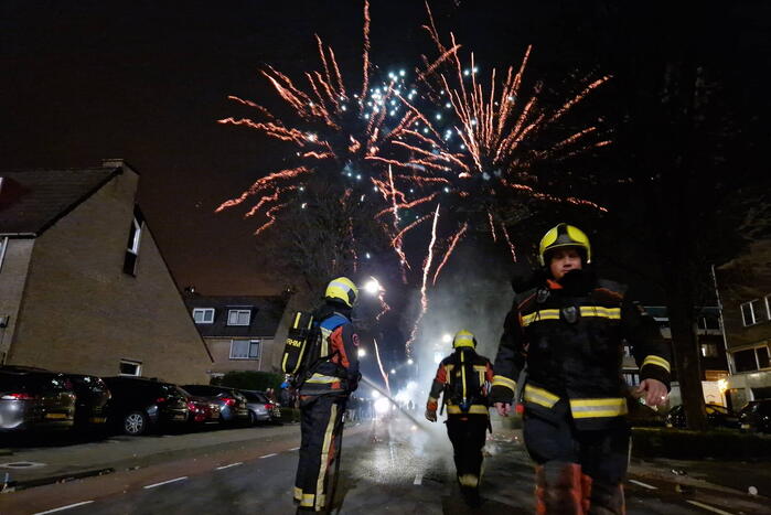 Brandweer blust brandend vuurwerkafval