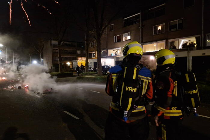 Brandweer blust brandend vuurwerkafval