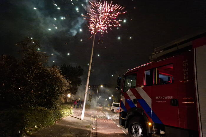 Brandweer blust brandend vuurwerkafval
