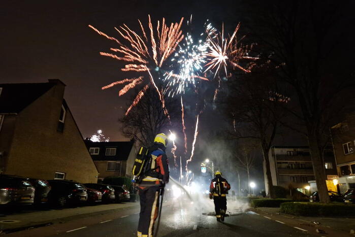 Brandweer blust brandend vuurwerkafval
