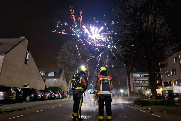 Brandweer blust brandend vuurwerkafval
