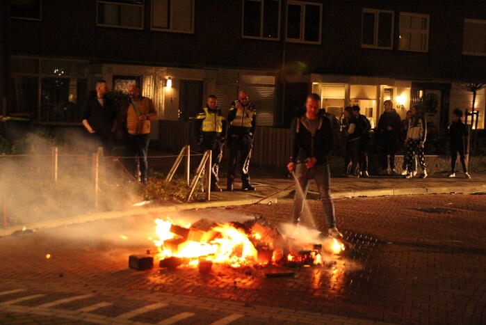 Brandweer blust brandende vuurwerkpotten