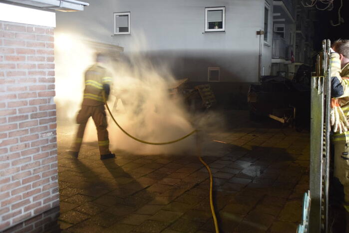 Brandweer blust brandende vuurton in achtertuin
