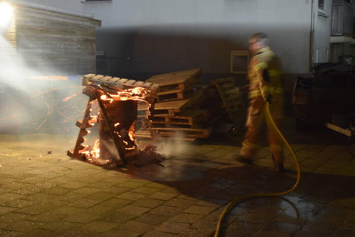 Brandweer blust brandende vuurton in achtertuin