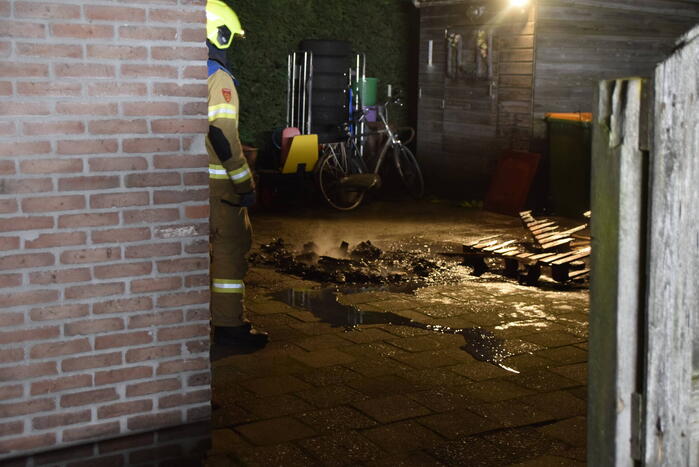 Brandweer blust brandende vuurton in achtertuin