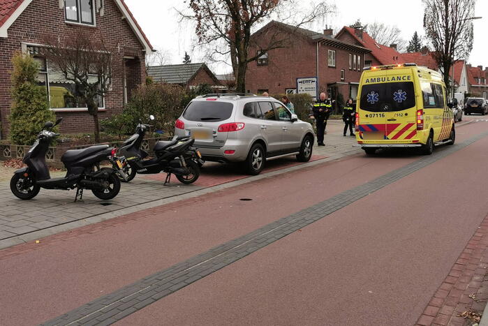 Twee scooterrijders ten val na botsing met geparkeerde auto