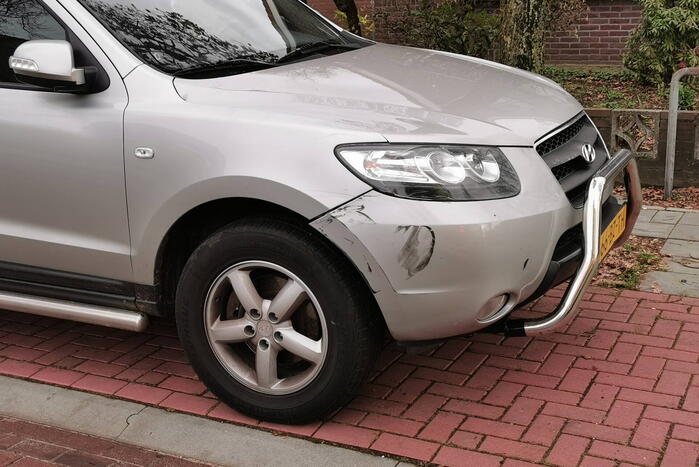 Twee scooterrijders ten val na botsing met geparkeerde auto