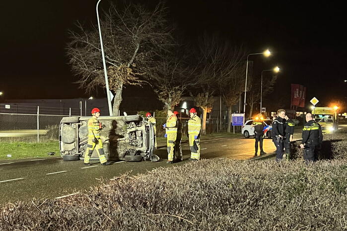 Auto op zijn zijkant na botsing met lantaarnpaal