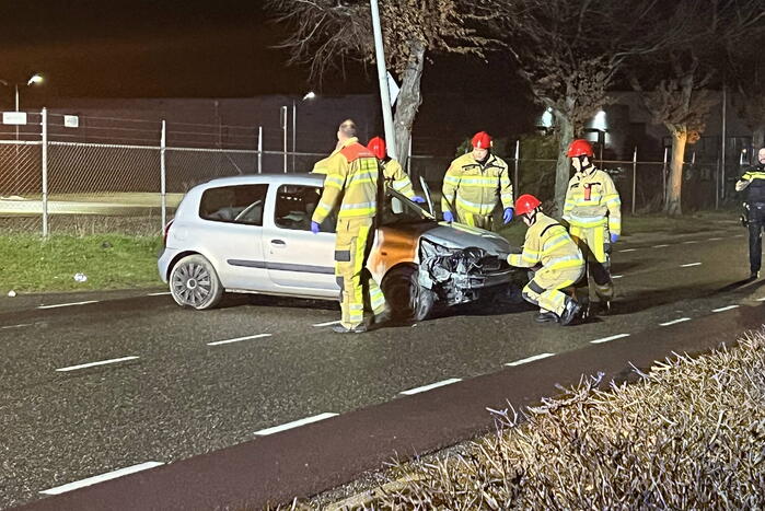 Auto op zijn zijkant na botsing met lantaarnpaal