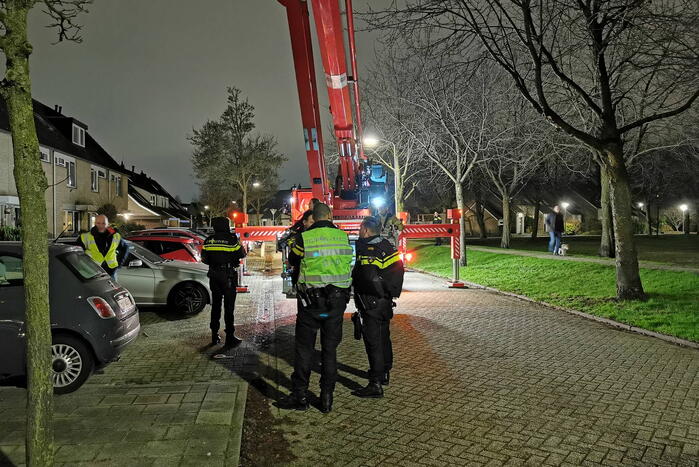 Persoon klimt op dak van woning