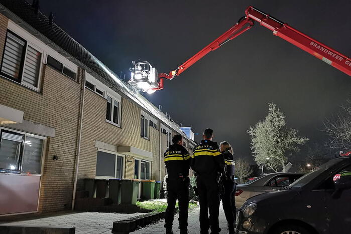 Persoon klimt op dak van woning
