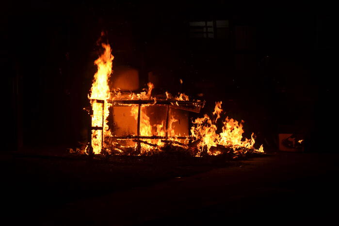 Grofvuil in brand naast afvalcontainer