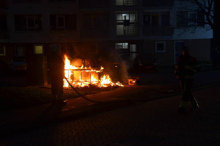 Grofvuil in brand naast afvalcontainer