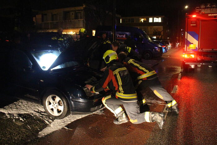 Brand onder motorkap van auto