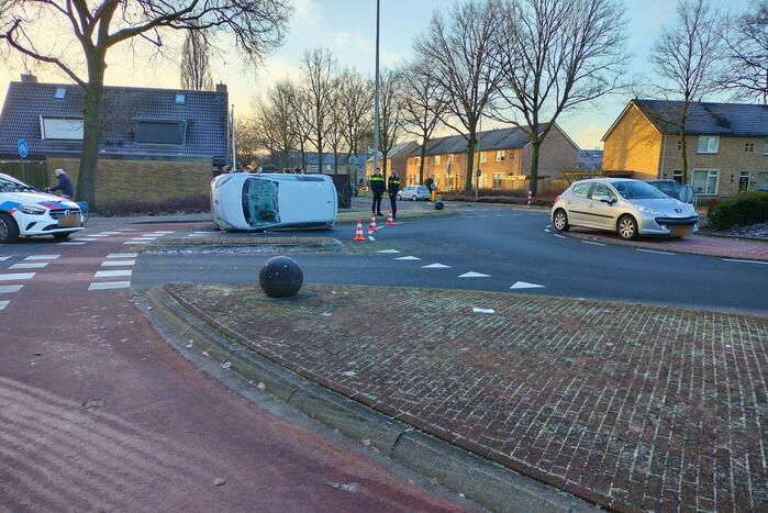 Auto belandt op zijn kant op rotonde
