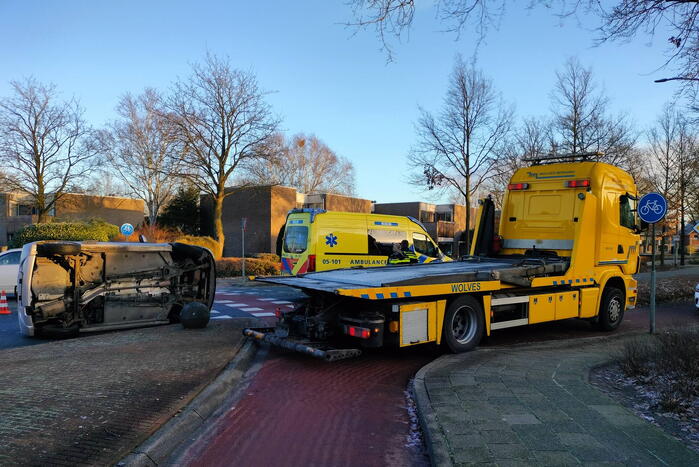 Auto belandt op zijn kant op rotonde