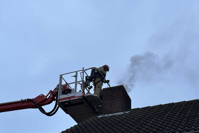 Brandweer veegt schoorsteen na brand