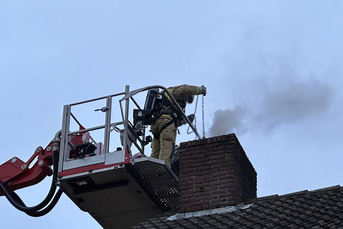 Brandweer veegt schoorsteen na brand