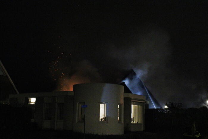 Uitslaande brand in tuinhuis slaat over naar woning