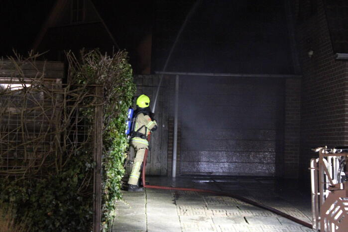 Uitslaande brand in tuinhuis slaat over naar woning