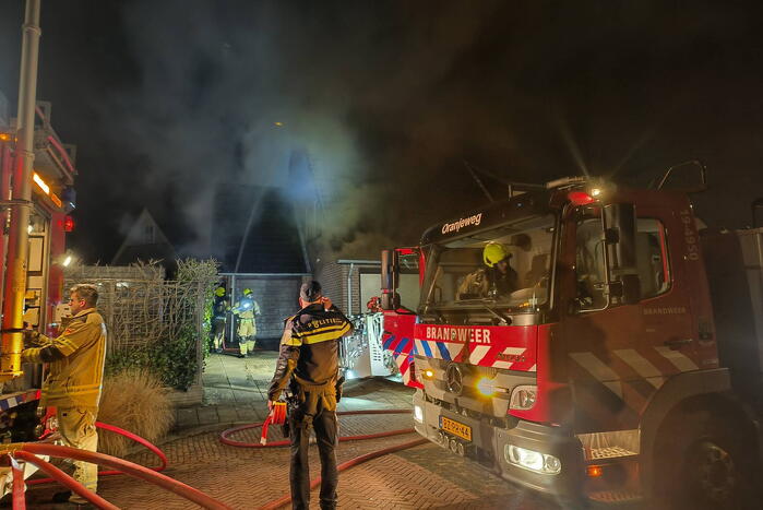 Uitslaande brand in tuinhuis slaat over naar woning