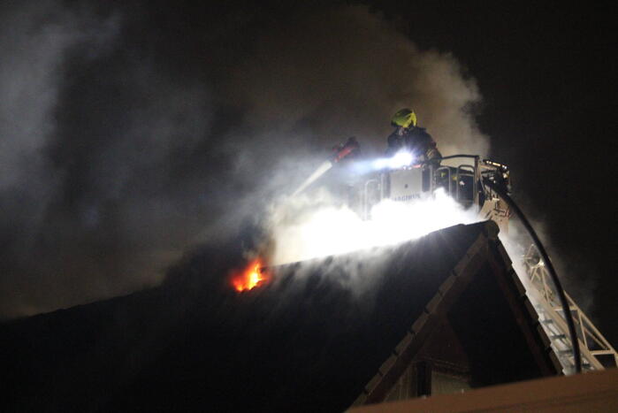 Uitslaande brand in tuinhuis slaat over naar woning