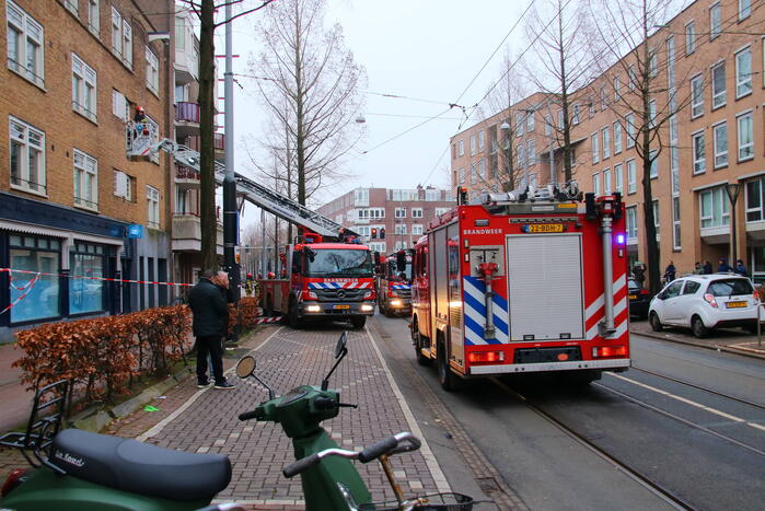 Brandweer met veel wagens naar woningbrand