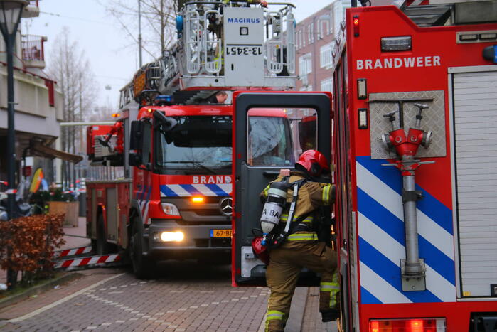 Brandweer met veel wagens naar woningbrand